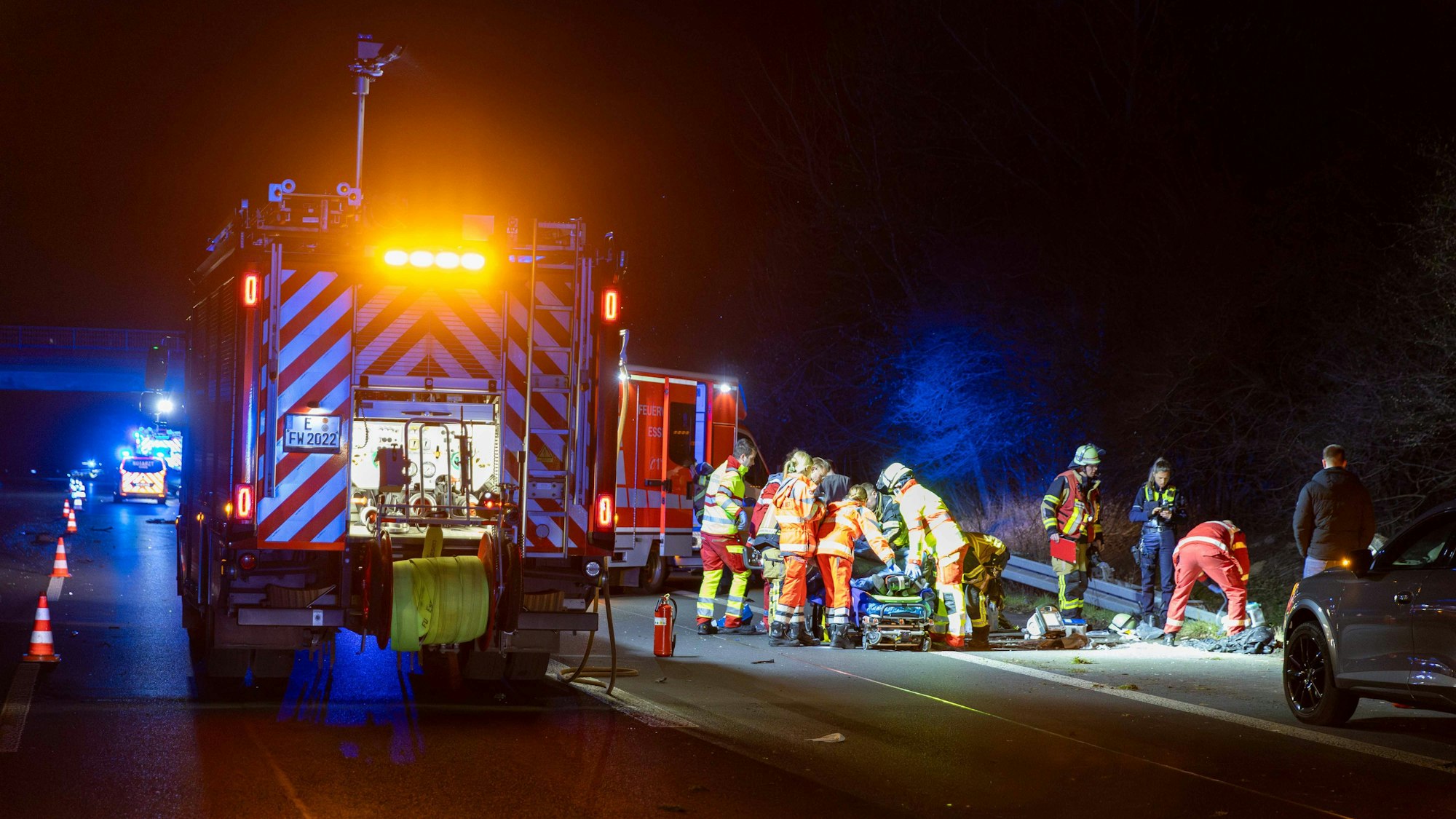 Einsatzkräfte kümmern sich nach einem Verkehrsunfall auf der Autobahn 52 um einen Verletzten. Bei dem Verkehrsunfall ist eine 54-jährige Frau lebensgefährlich verletzt worden.