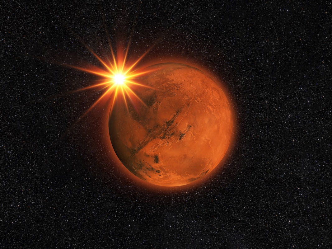 Roter Planet Mars mit Sonnenstrahlen am Sternenhimmel.