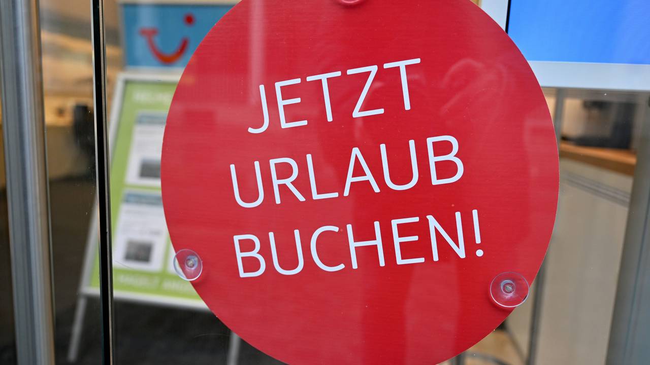 Ein Schild mit der Aufschrift „Jetzt Urlaub buchen!“ hängt in einem Reisebüro in der Münchener Innenstadt. Wer clever bucht, kann bares Geld sparen.