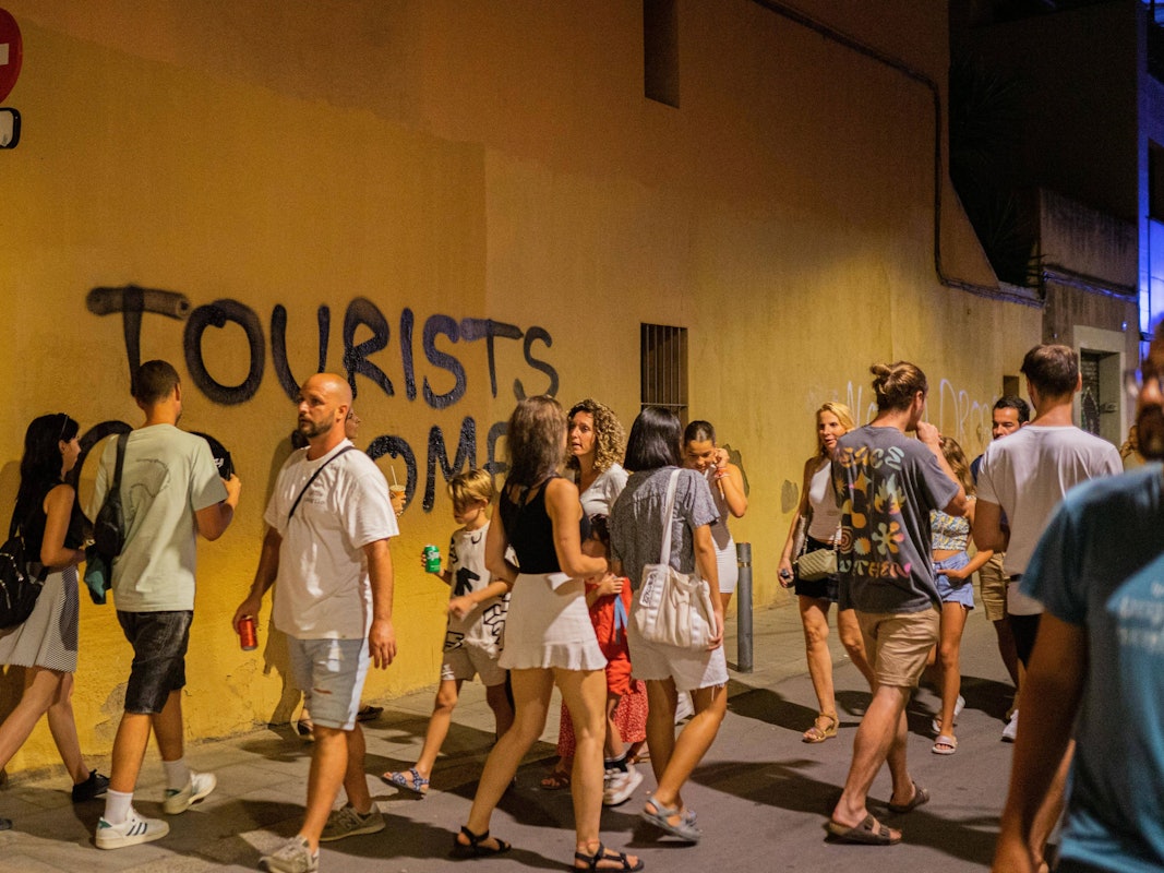 Ein Graffiti in Barcelona zeigt eine eindeutige Botschaft (2023): „Tourists go home“ – „Touristen, geht nach Hause“, steht dort.