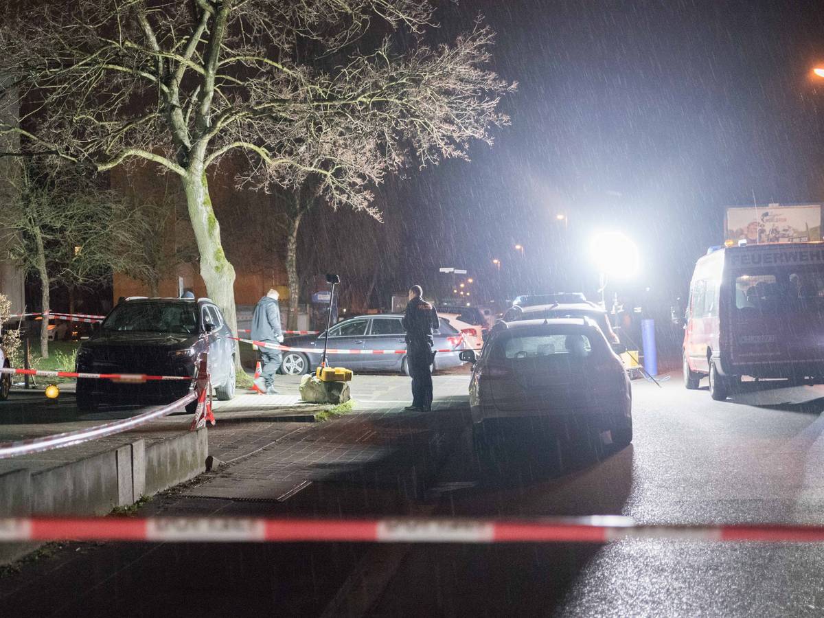 Polizei und Feuerwehr arbeiten an einem Tatort, die Straße ist abgesperrt.