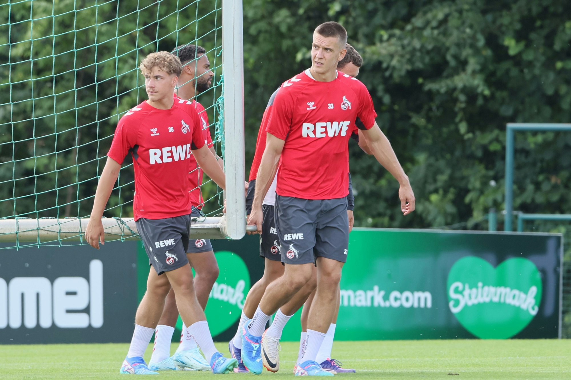 Meiko Wäschenbach und Florian Dietz tragen gemeinsa ein Tor.