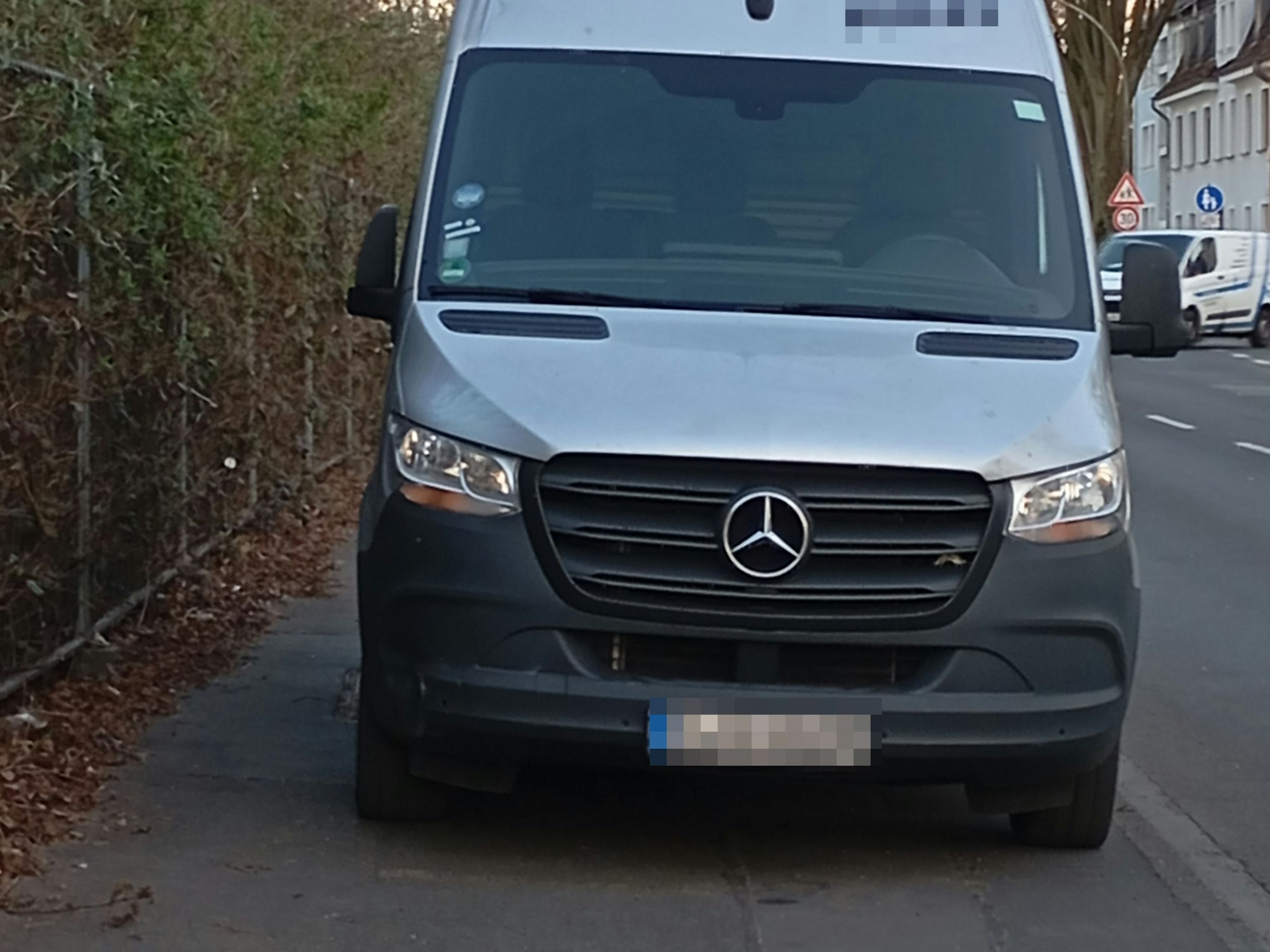 Ein Transporter blockiert einen Fußweg in Köln.