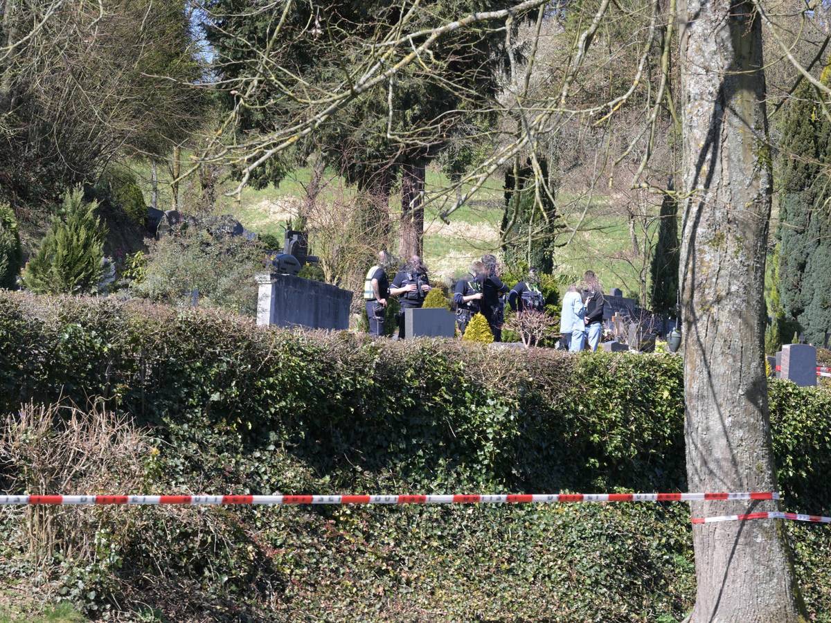 Ein Friedhof ist mit Polizei-Flatterband abgesperrt, zwischen Gräbern stehen unter anderem Polizeikräfte.