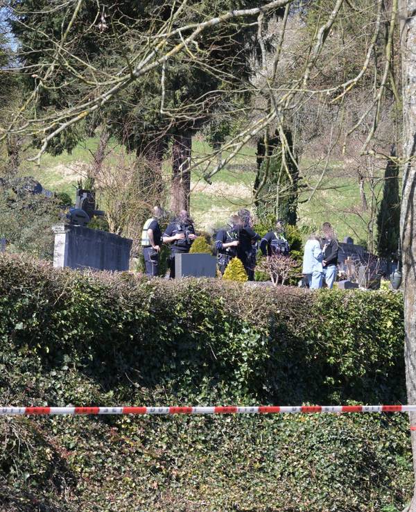 Die Polizei hat einen Friedhof abgesperrt, zwischen den Gräbern sind Polizeikräfte im Einsatz.