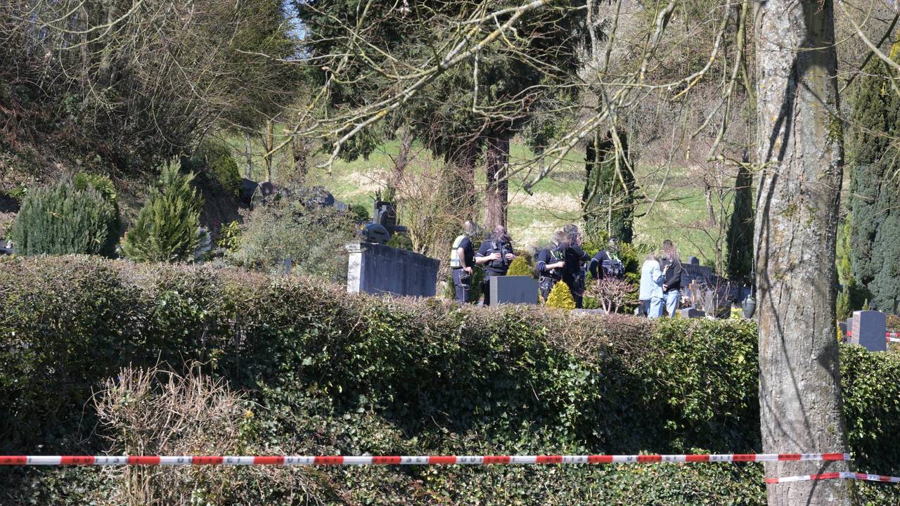 Die Polizei hat einen Friedhof abgesperrt, zwischen den Gräbern sind Polizeikräfte im Einsatz.