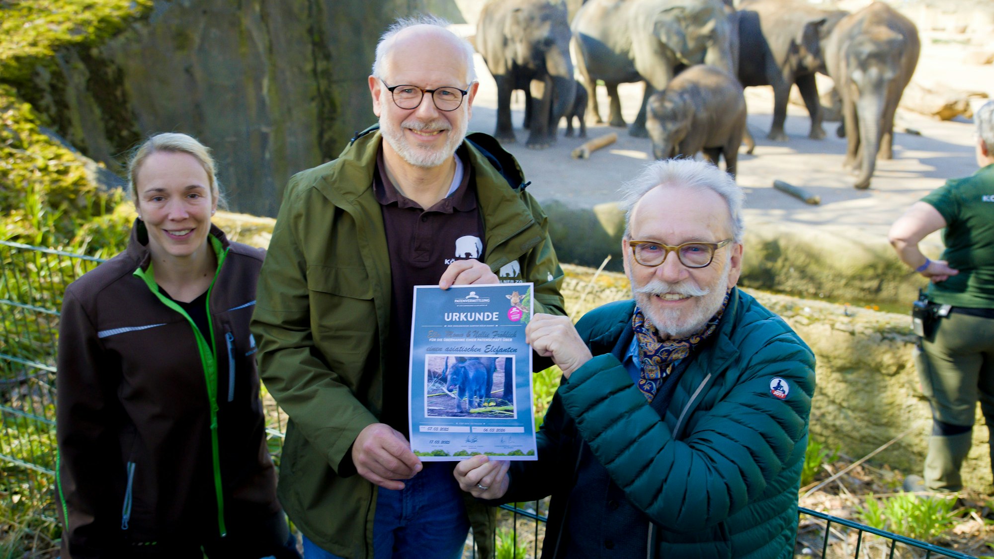 Tierärztin Sandra Marcordis (li.), Zoodirektor Theo Pagel (Mitte) und Janus Fröhlich, Pate des neugeborenen Elefantenbullens im Kölner Zoo.