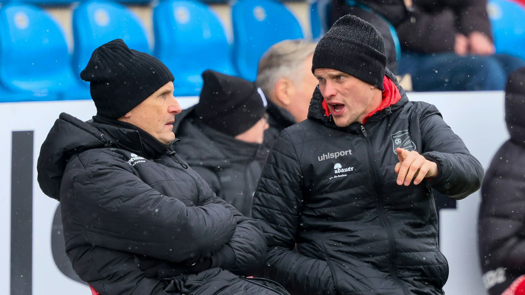 Unterhachings Trainer Heiko Herrlich und Co-Trainer Sven Bender diskutieren auf der Bank.