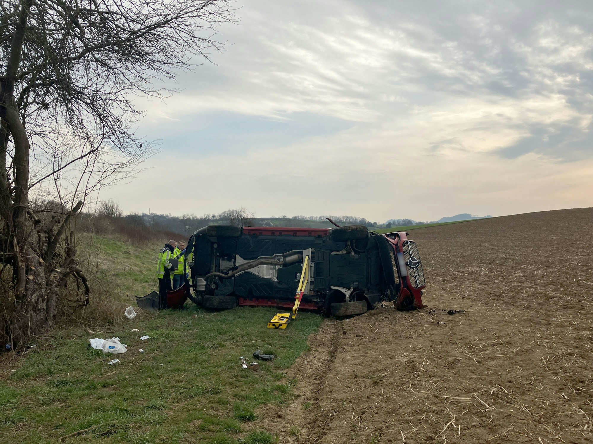 Ein Fahrzeug liegt am 23. März an der Anschlussstelle Bretzfeld auf der A6 in einem Feld. Bei einem schweren Verkehrsunfall auf der Autobahn 6 östlich von Heilbronn sind zwei Menschen gestorben - vier weitere Menschen wurden schwer verletzt.