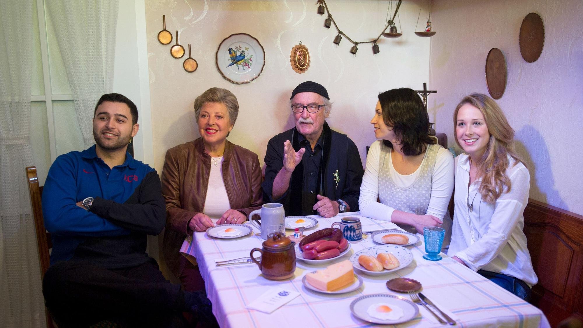 Die Schauspieler Hüseyin Ekici (Orkan Kortuglu, v.l.), Marie-Luise Marjan (Helga Beimer), der Produzent der Fernsehserie „Lindenstraße“, Hans W. Geißendörfer, und die Schauspielerinnen Daniela Bette (Angelina Buchstab) und Clara Dolny (Josi Stadler) sitzen im Museum Wilhelmsbau am Technik Museum in der Originalkulisse der Wohnküche der „Lindenstraße“-Hausmeisterin Else Kling.