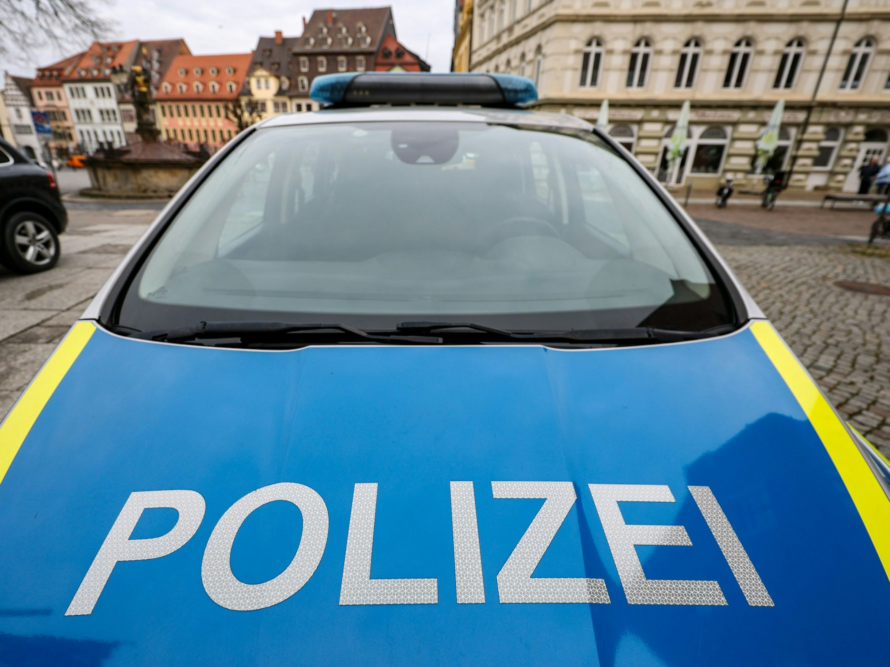 Ein Polizeiauto steht auf einem Platz.