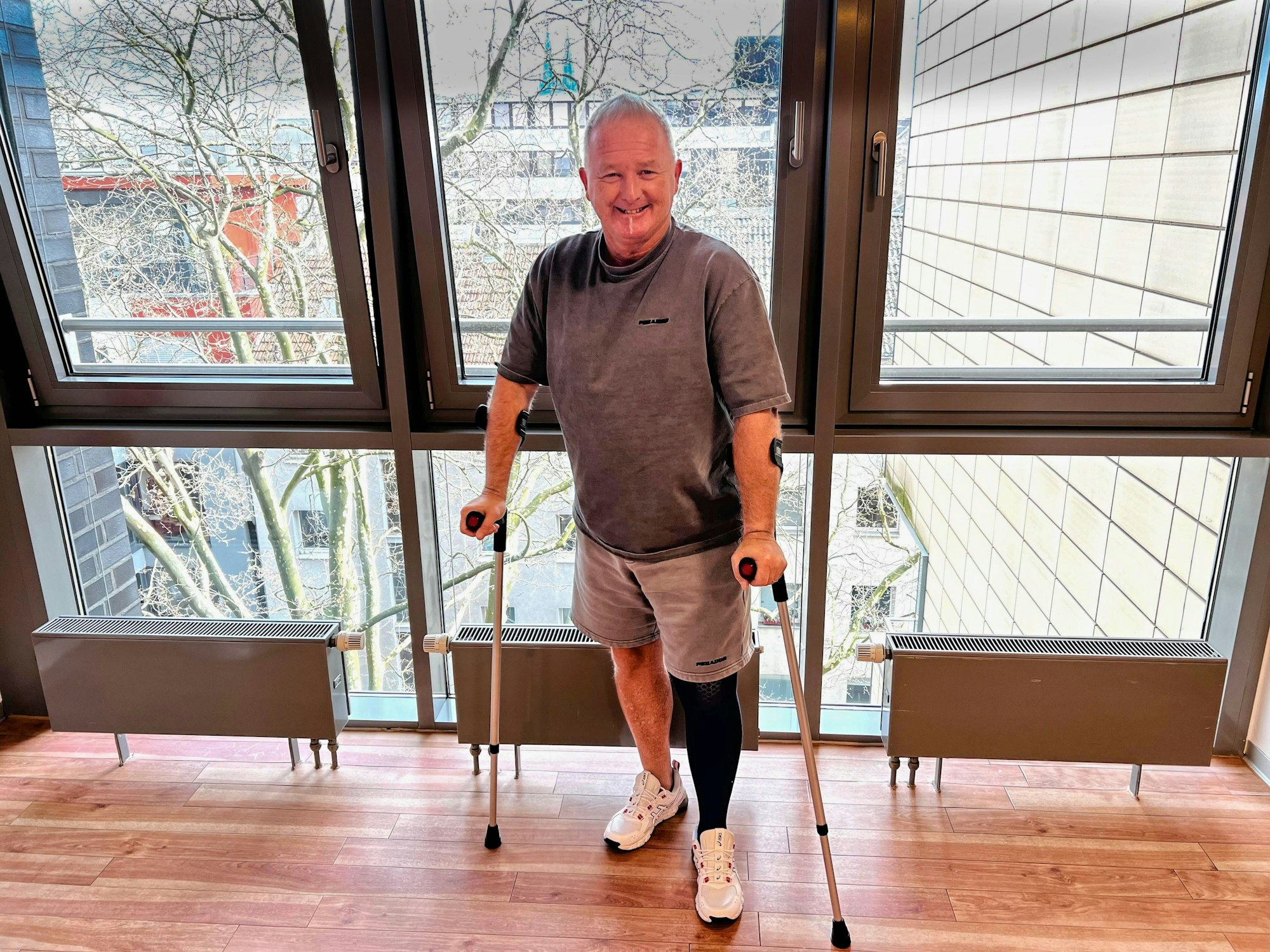 Micki Schläger steht mit Krücken auf dem Gang.