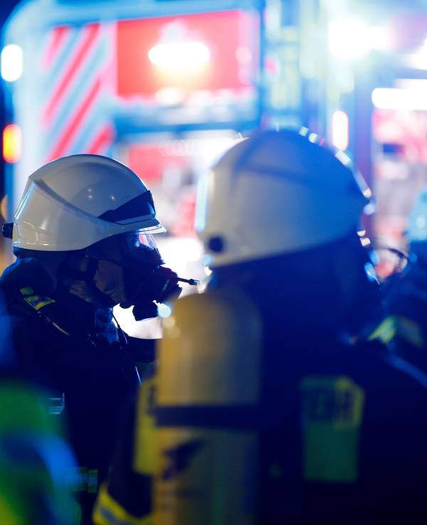 Einsatzkräfte der Berufsfeuerwehr Köln tragen bei einem Einsatz Atemschutzmasken.