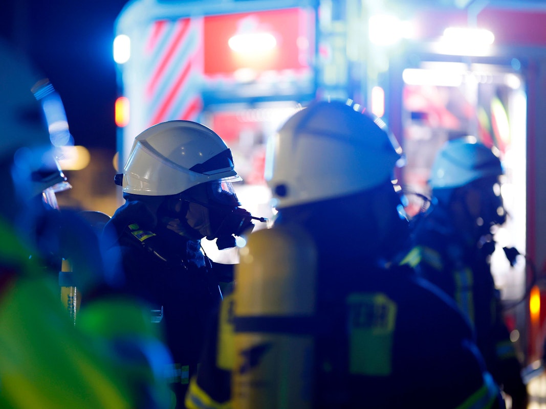 Einsatzkräfte der Berufsfeuerwehr Köln tragen bei einem Einsatz Atemschutzmasken.