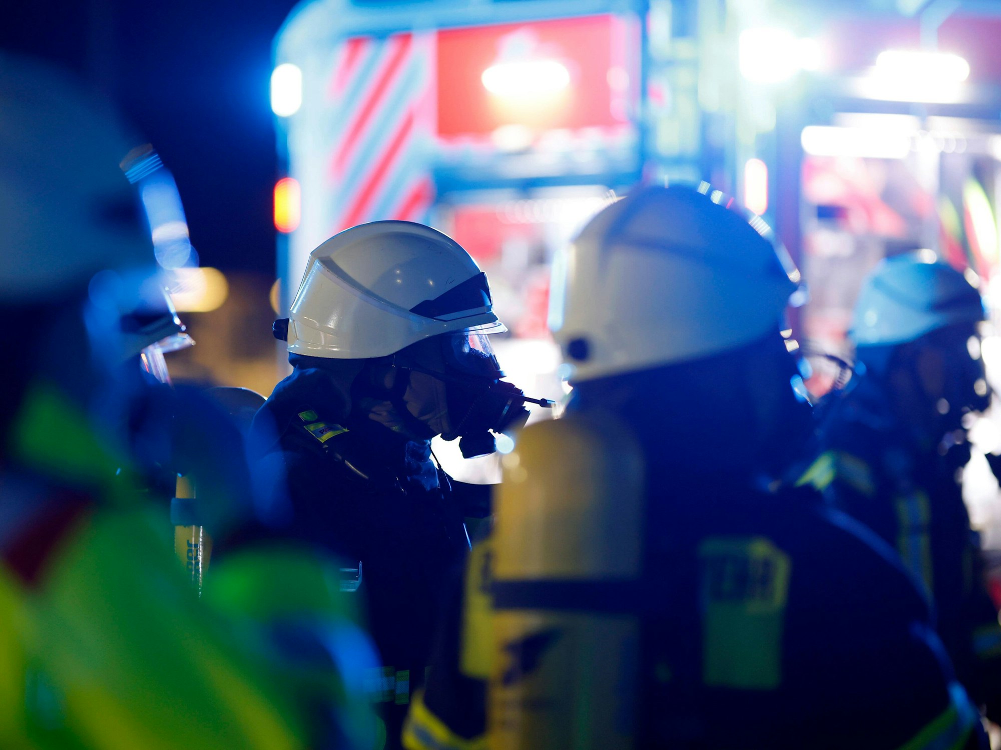Einsatzkräfte der Berufsfeuerwehr Köln tragen bei einem Einsatz Atemschutzmasken.
