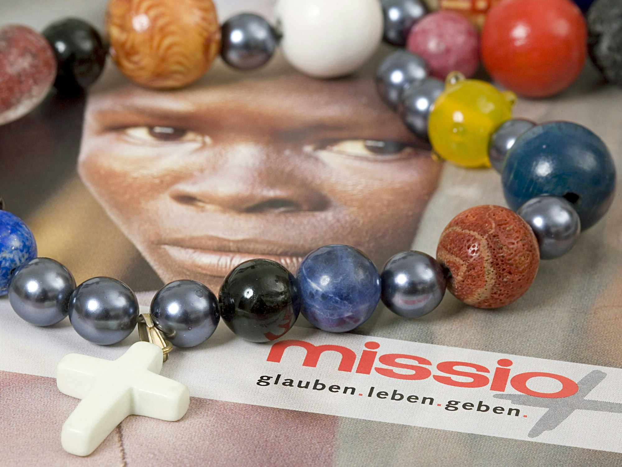 Eine so genannte Gebetskette liegt auf einer Postkarte, die symbolisch das Thema "Kindersoldaten" aufgreift (Foto vom 02.02.2007). Anlässlich des 175-jährigen Bestehens des Aachener Werkes startet missio, das Missionswerk der katholischen Kirche in Deutschland, in diesem Jahr eine Gebetsinitiative.