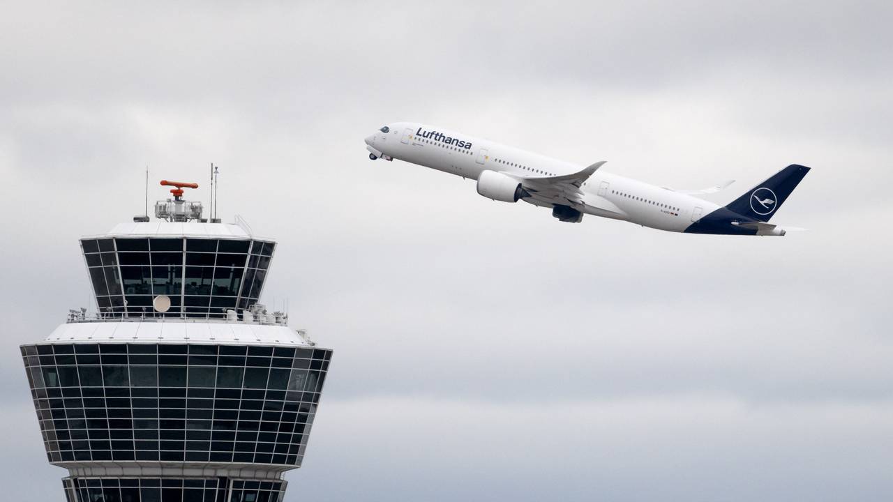 Ein Flugzeug der Lufthansa startet am Flughafen München und fliegt am Tower vorbei.