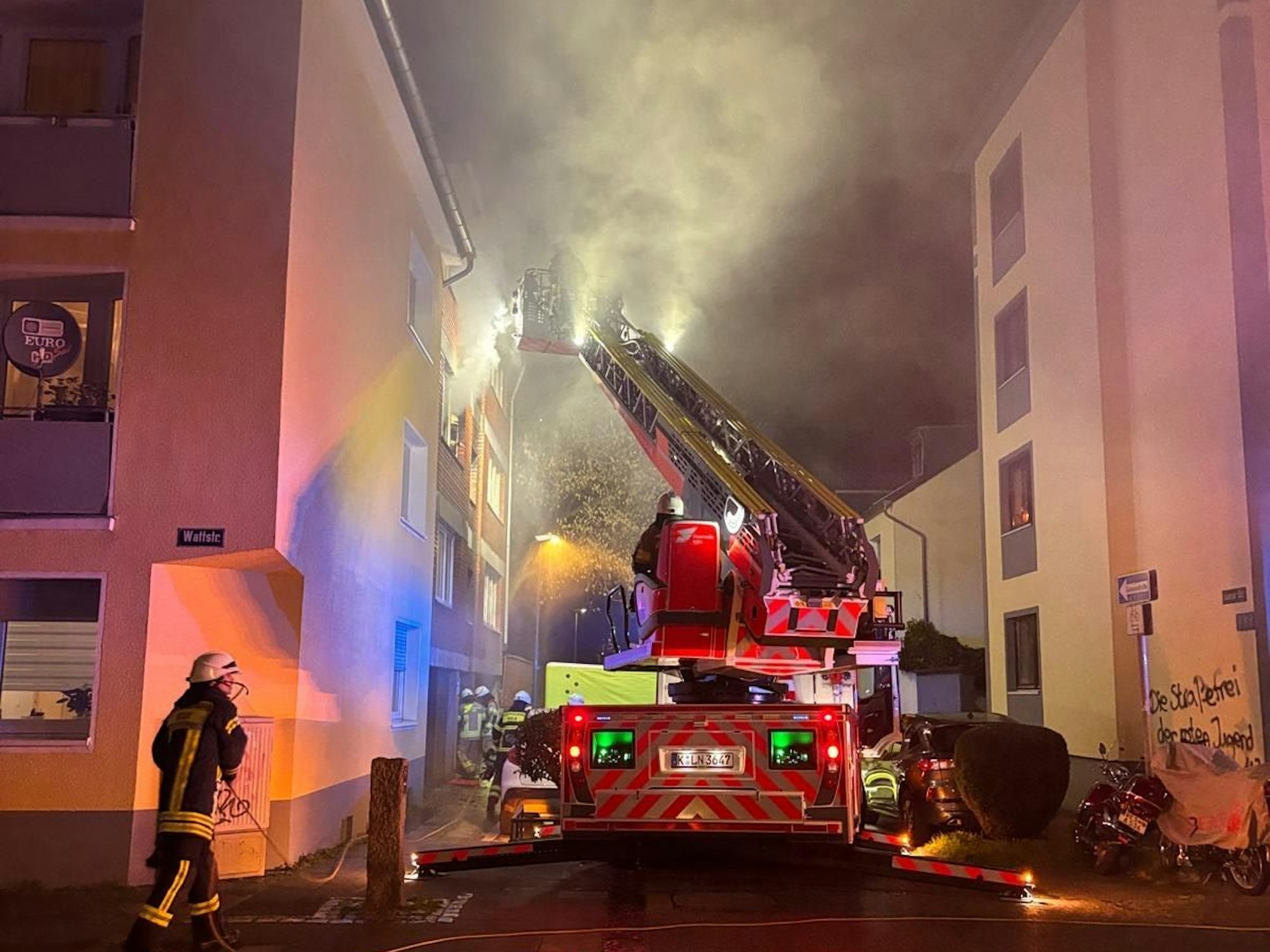 Die Feuerwehr löscht einen Brand in einem Mehrfamilienhaus.