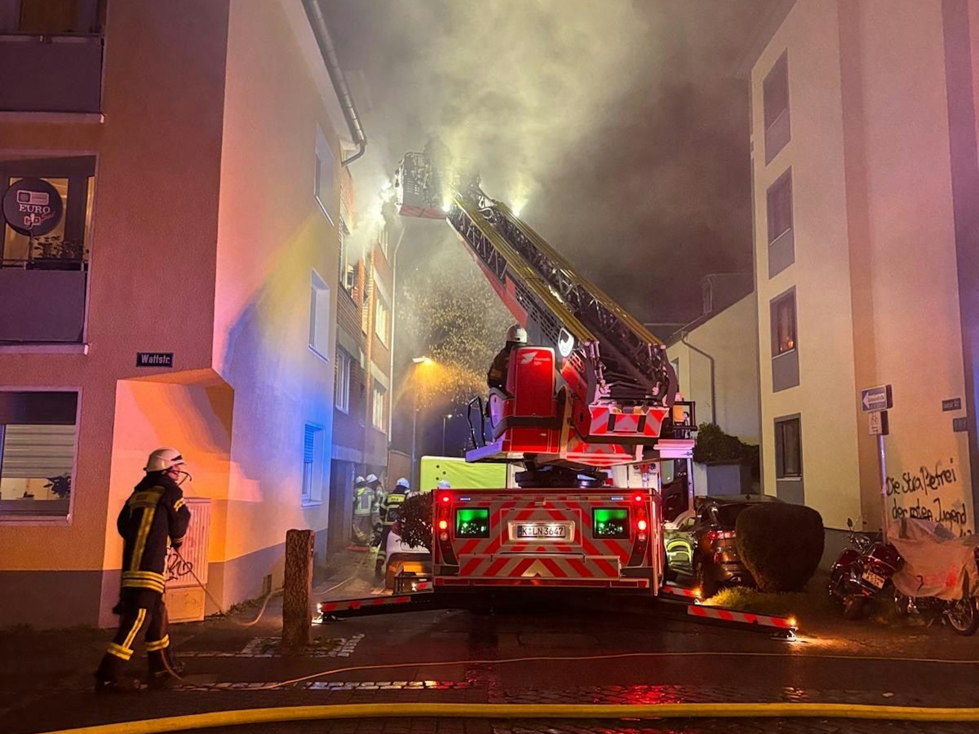Die Feuerwehr löscht einen Brand in einem Mehrfamilienhaus.