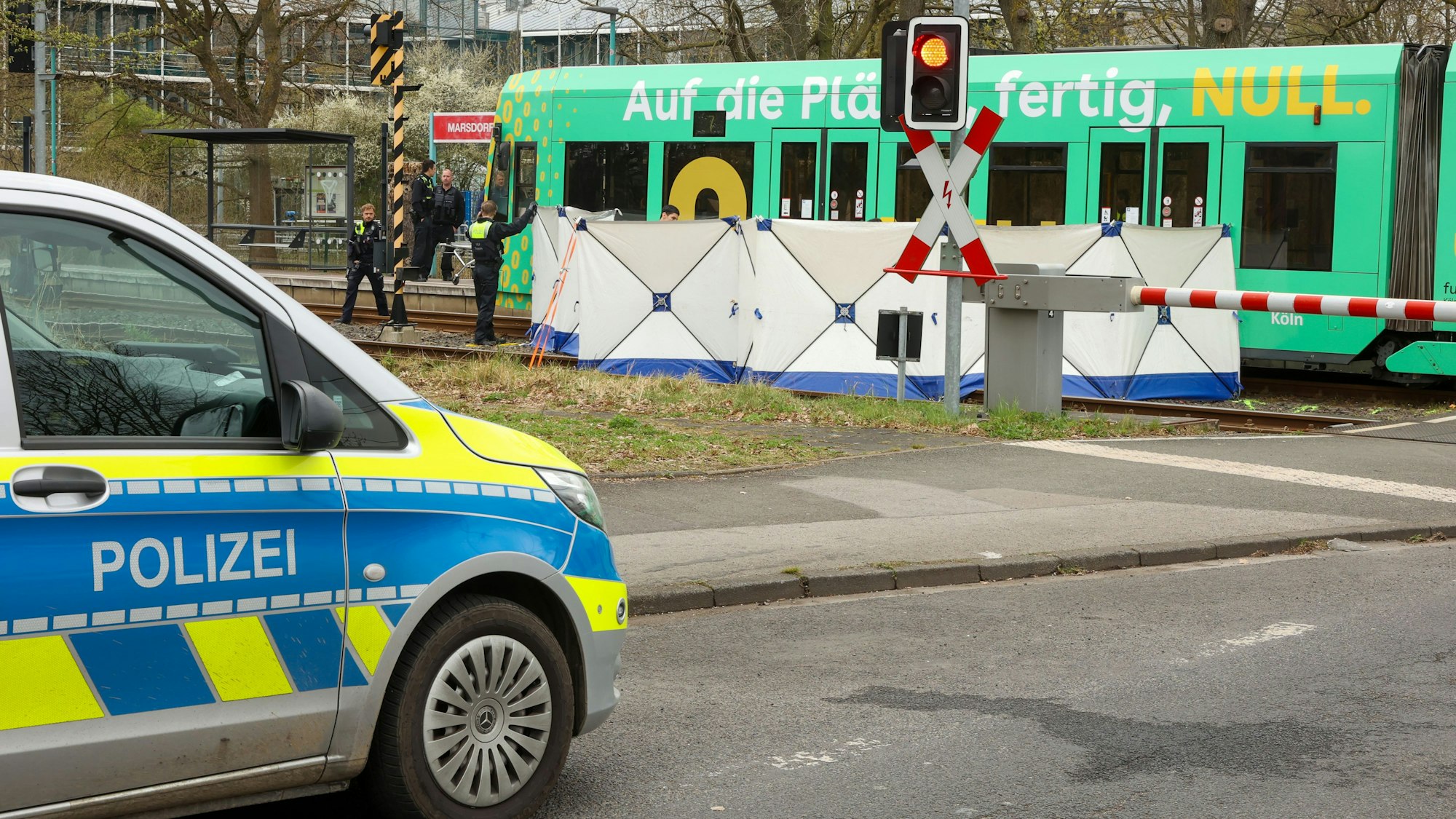 Vor einer stehenden Straßenbahn ist ein Sichtschutz aufgebaut.