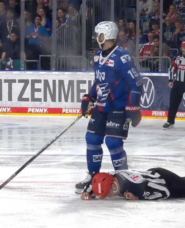 Der Linesman liegt nach einem Check auf dem Eis.