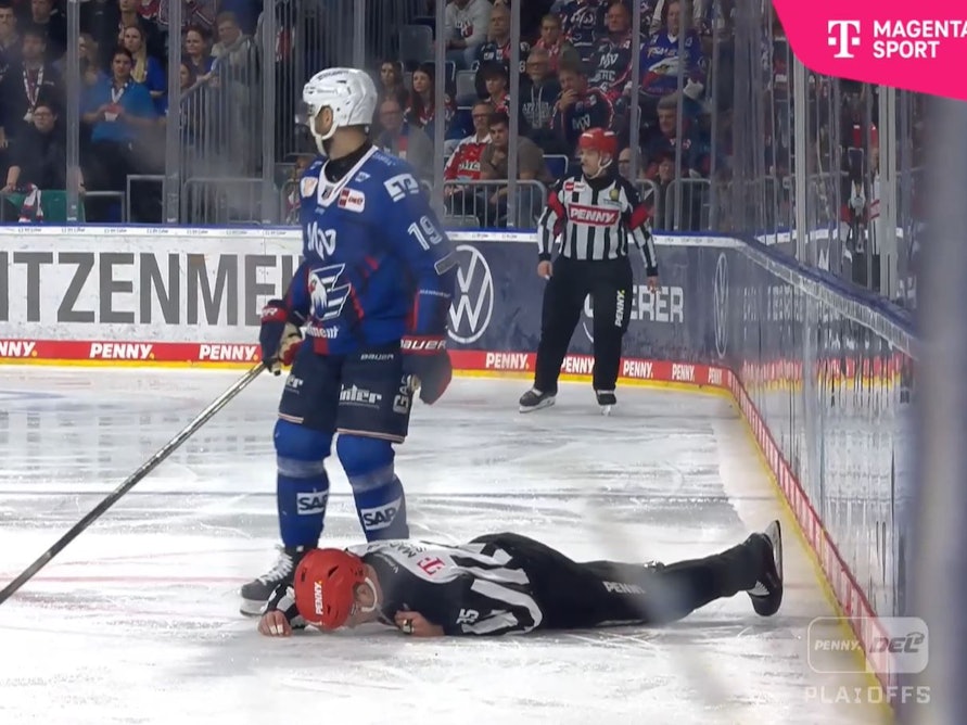 Der Linesman liegt nach einem Check auf dem Eis.
