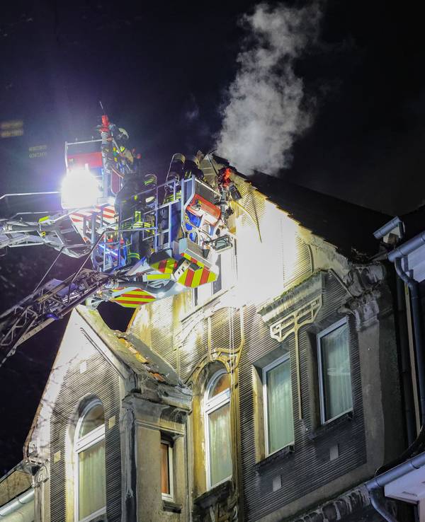 Feuerwehrleute arbeiten mit zwei Drehleitern an einem Brand.