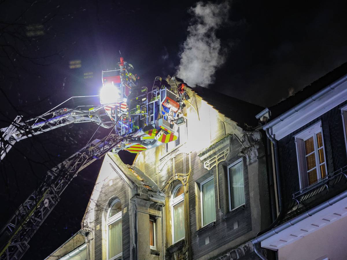Feuerwehrleute arbeiten mit zwei Drehleitern an einem Brand.