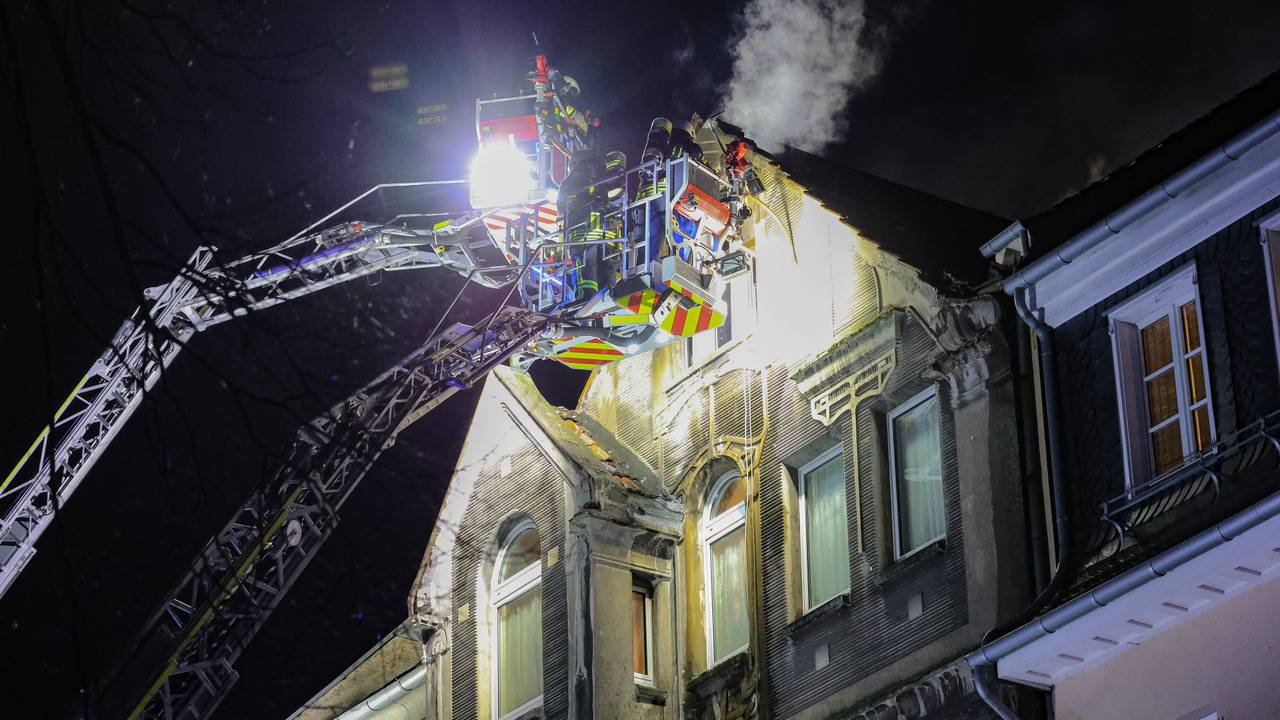Feuerwehrleute arbeiten mit zwei Drehleitern an einem Brand.
