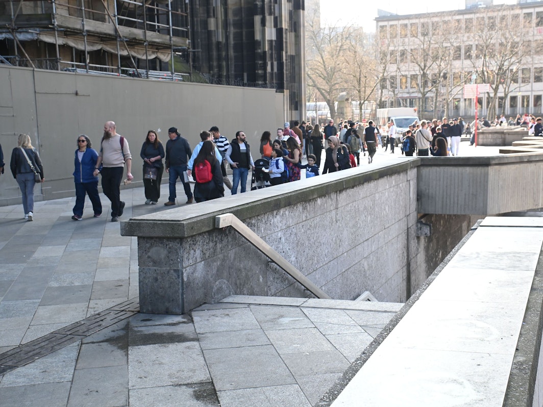 Menschen gehen am Dom entlang.
