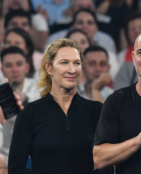 Steffi Graf steht neben Andre Agassi auf einem Tennisplatz.