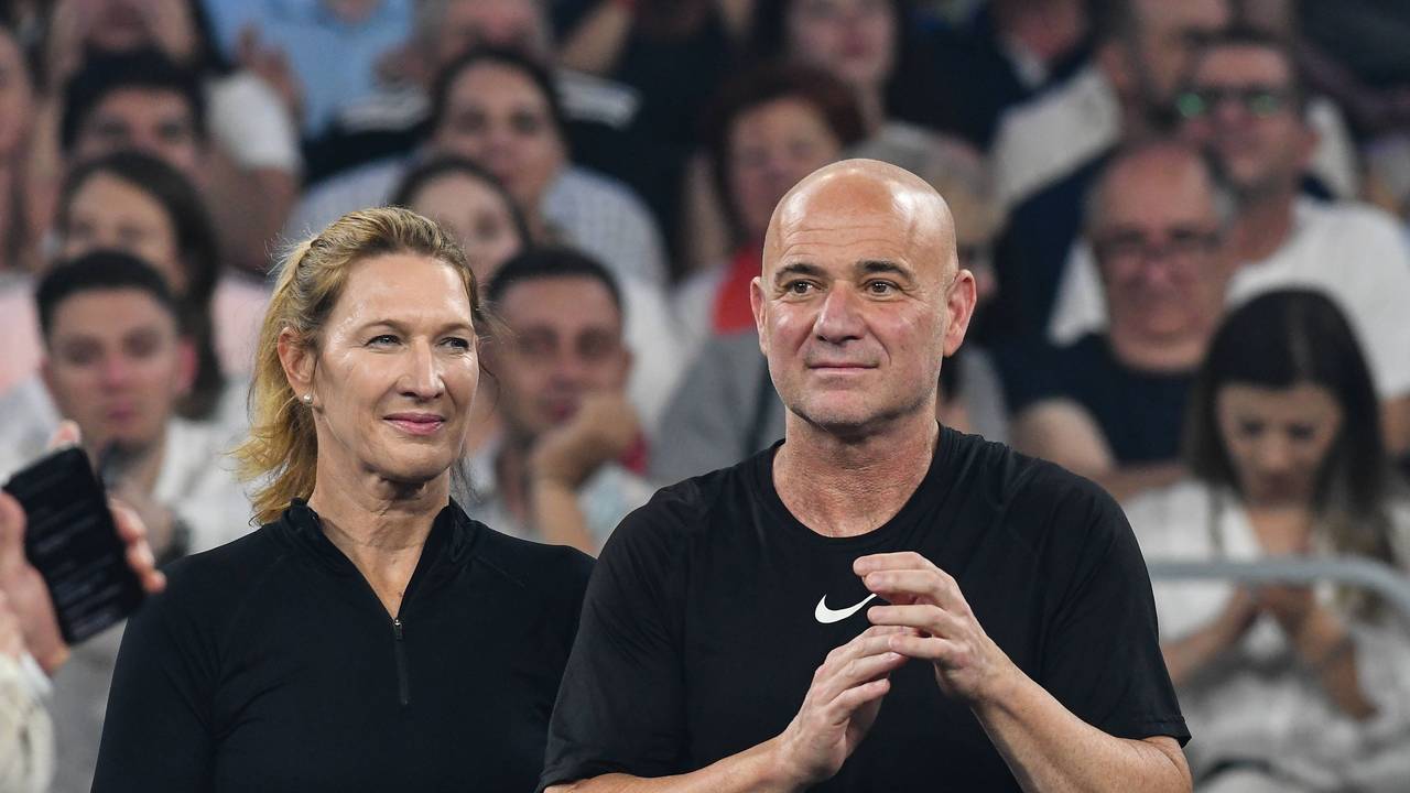 Steffi Graf steht neben Andre Agassi auf einem Tennisplatz.