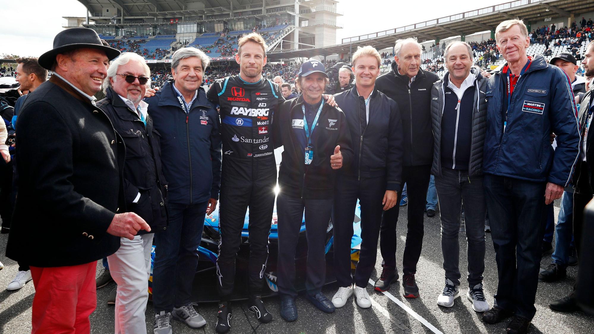 Jochen Mass, Keke Rosberg, Christian Geistdörfer, Jenson Button, Emerson Fittipaldi, Nico Rosberg, Hans-Joachim Stuck, Gerhard Berger, Walter Röhrl (von links nach rechts) posieren für ein Foto in Hockenheim.