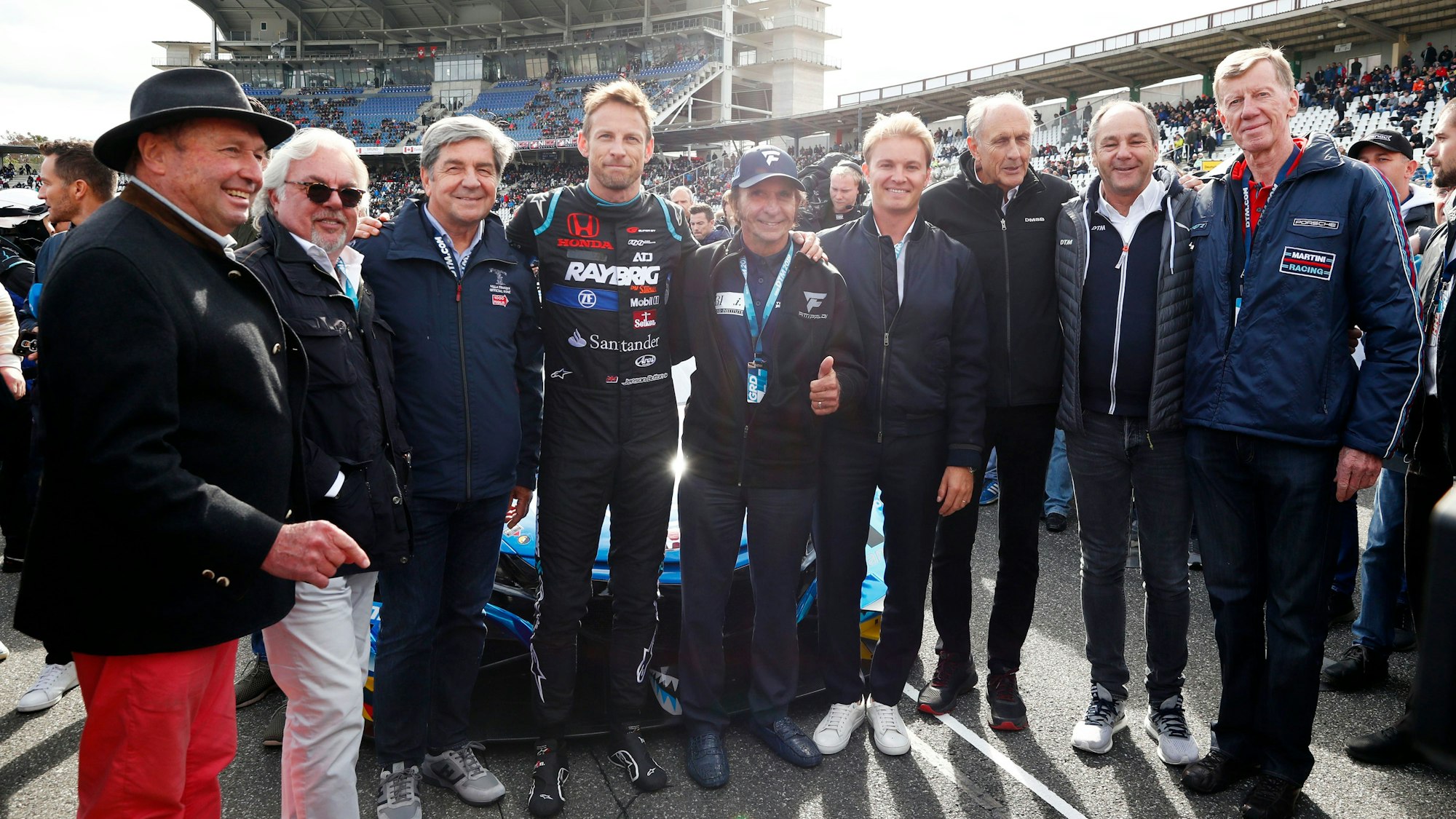 Jochen Mass, Keke Rosberg, Christian Geistdörfer, Jenson Button, Emerson Fittipaldi, Nico Rosberg, Hans-Joachim Stuck, Gerhard Berger, Walter Röhrl (von links nach rechts) posieren für ein Foto in Hockenheim.