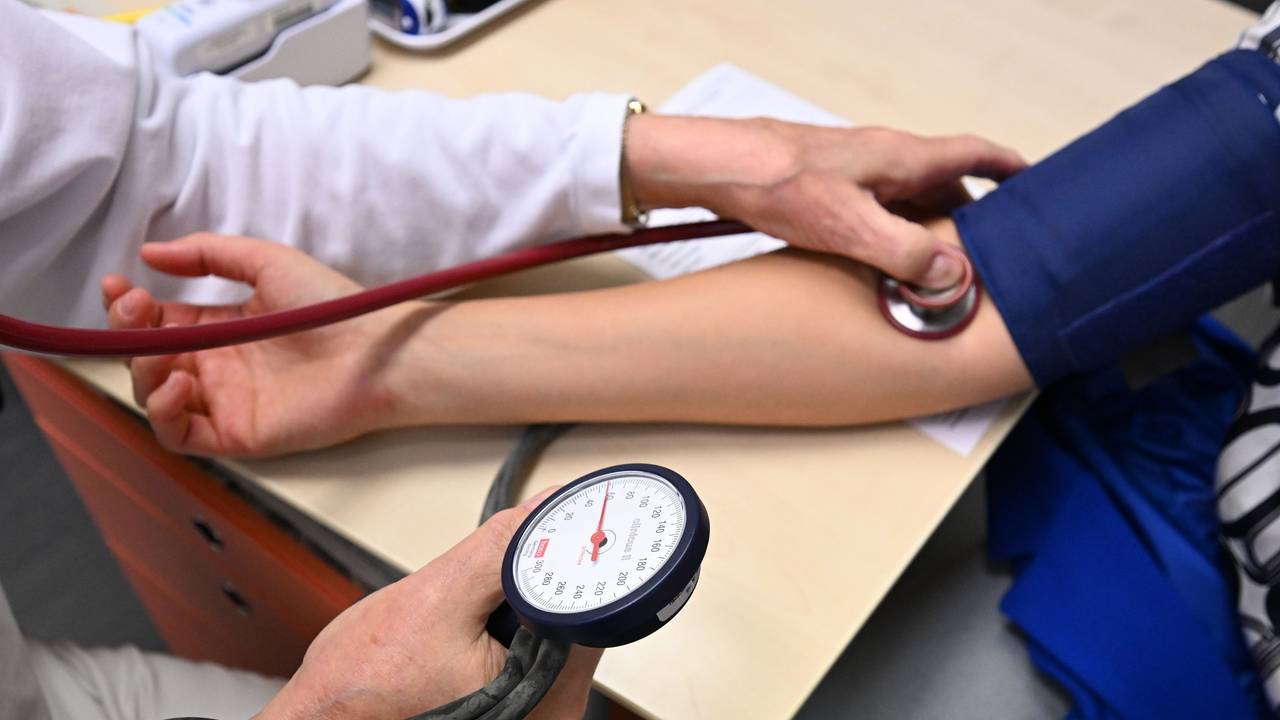 Ein Arzt misst in einer Bereitschaftspraxis in einem Krankenhaus in einem Untersuchungsraum bei einer Patientin den Blutdruck (gestellte Szene).