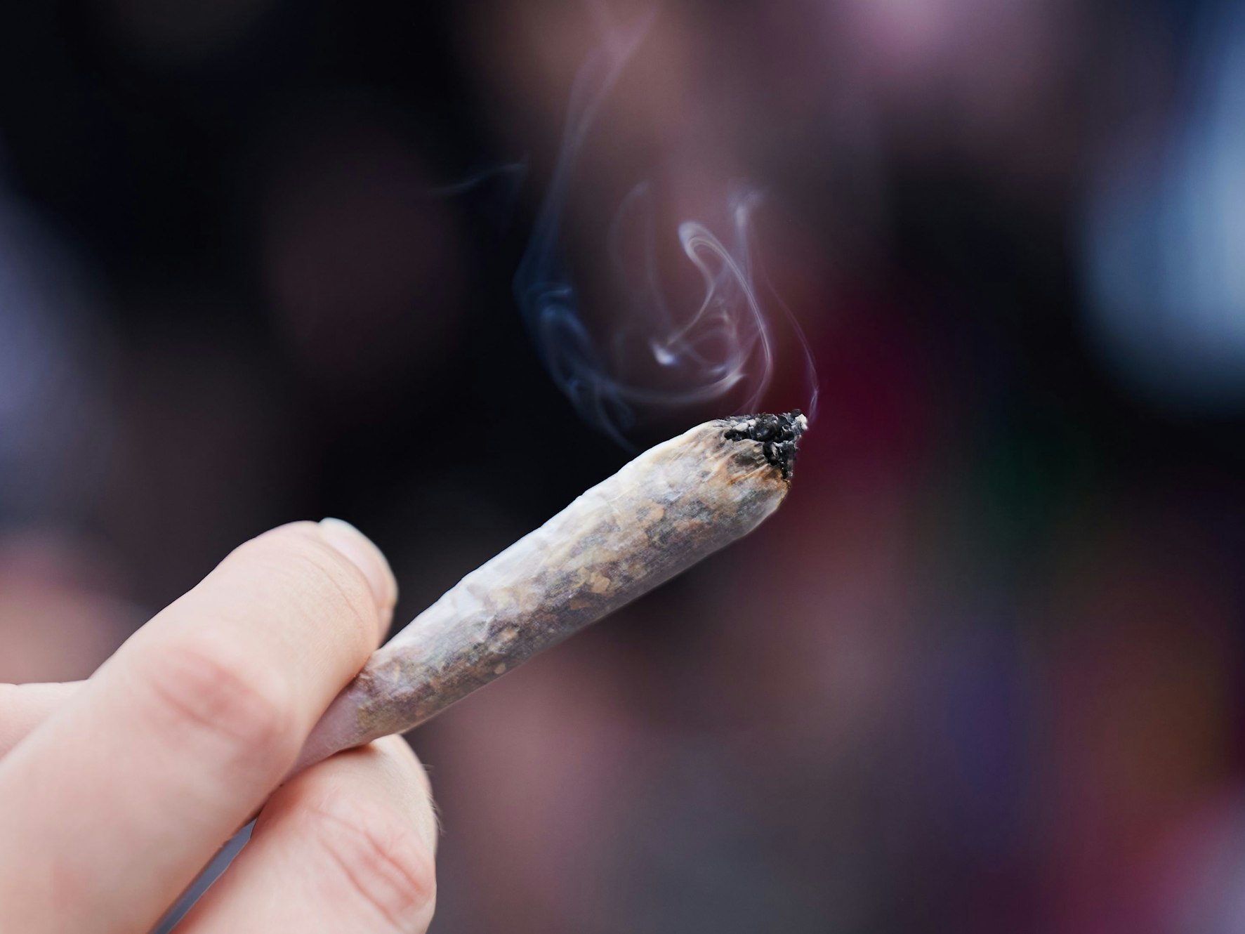 Eine Frau hält einen Joint in der Hand.