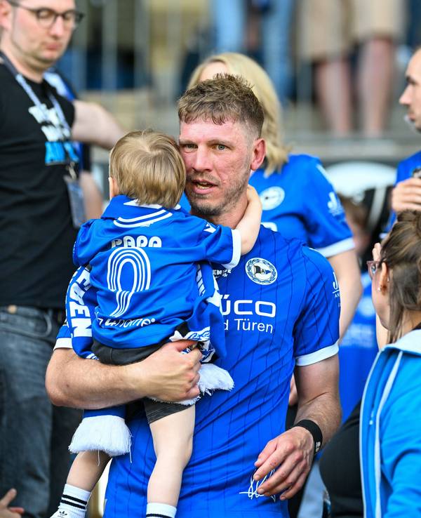 Arminia-Idol Fabian Klos hält seinen Sohn im Arm.