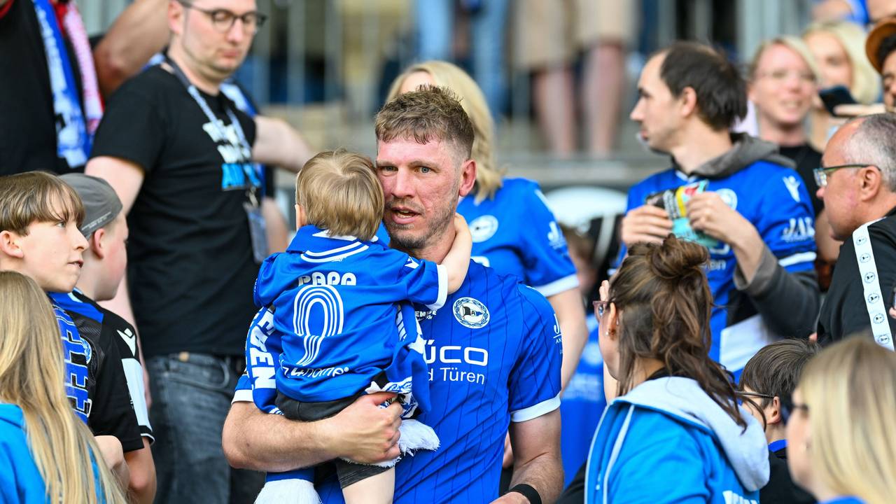 Arminia-Idol Fabian Klos hält seinen Sohn im Arm.