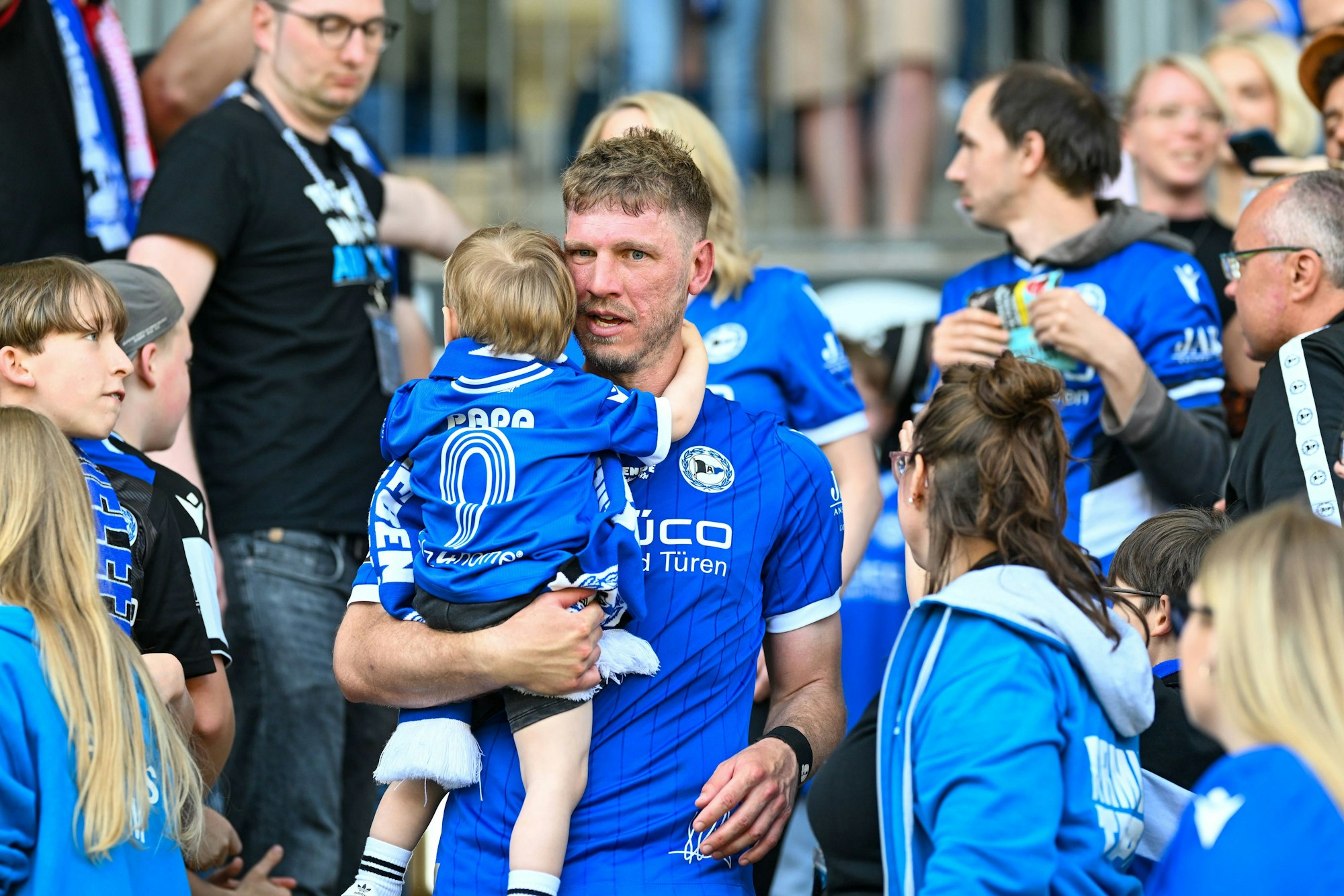 Arminia-Idol Fabian Klos hält seinen Sohn im Arm.