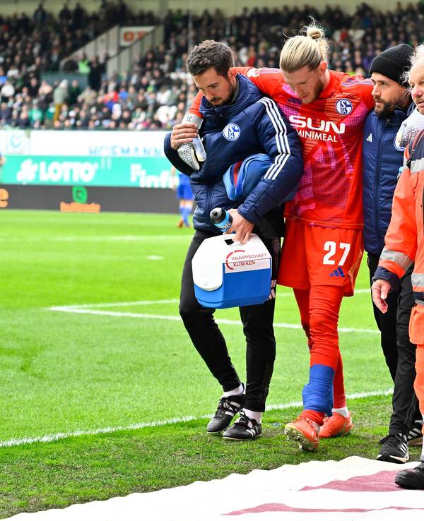 Loris Karius wird von zwei Betreuern gestützt.