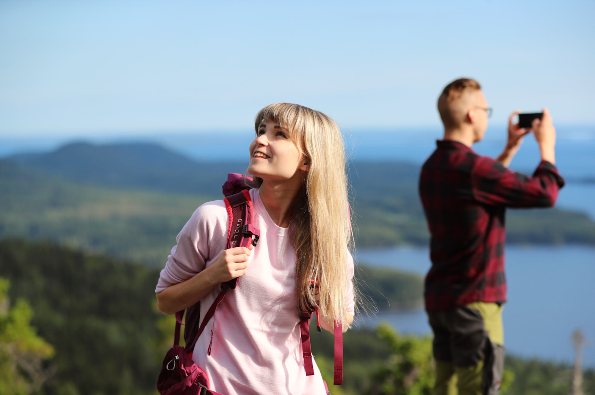 Zu sehen sind zwei Touristen bei einer Wanderung im Koli-Nationalpark.