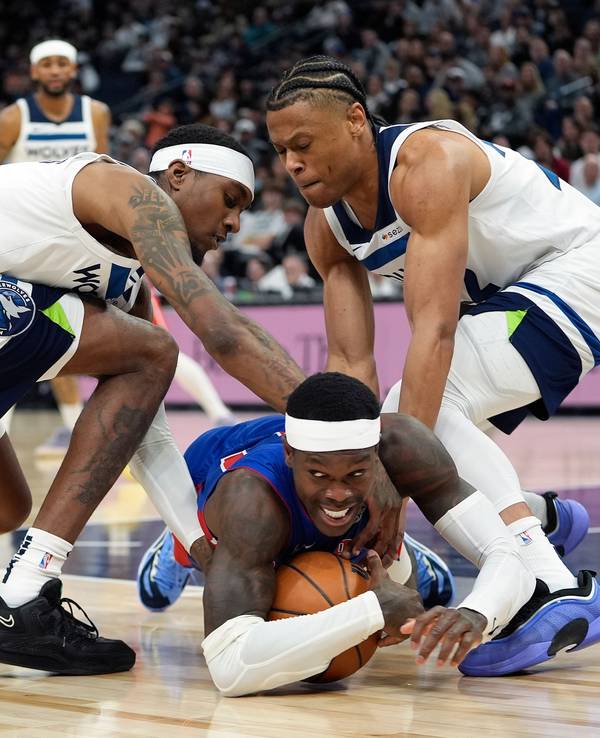 Detroit Pistons-Guard Dennis Schröder (M.), fällt, während Minnesota Timberwolves-Forward Jaden McDaniels, und Guard Jaylen Clark (r.), um den Ballbesitz kämpfen.
