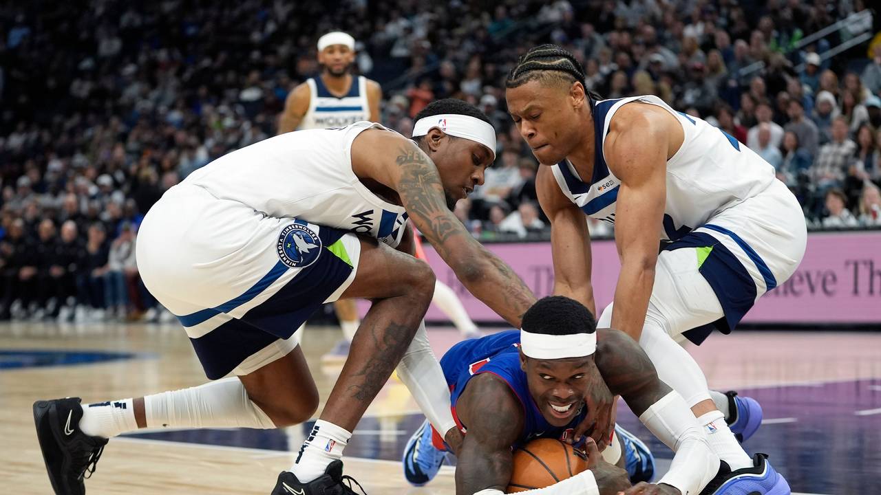 Detroit Pistons-Guard Dennis Schröder (M.), fällt, während Minnesota Timberwolves-Forward Jaden McDaniels, und Guard Jaylen Clark (r.), um den Ballbesitz kämpfen.