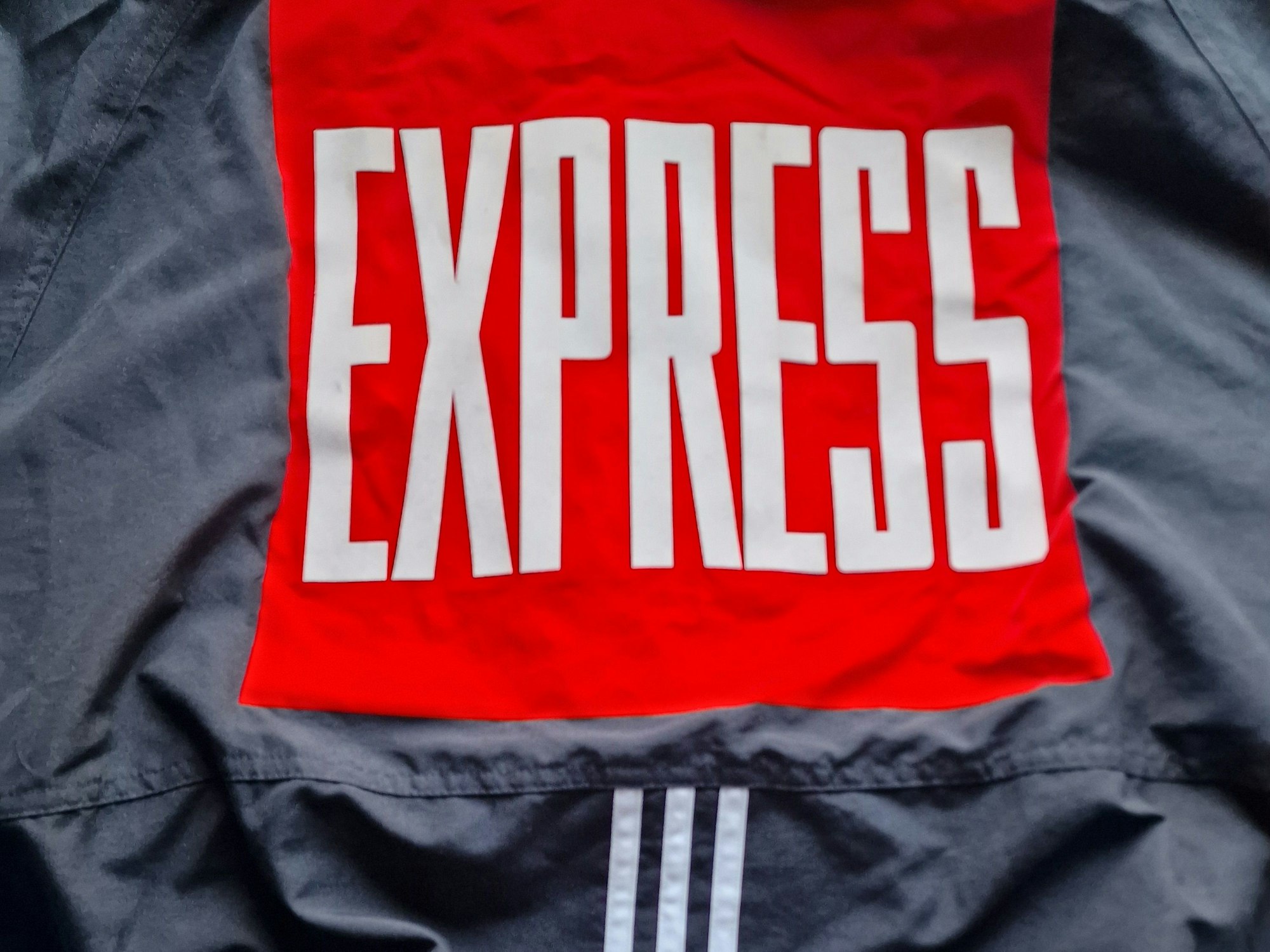 Auf einer Adidas-Jacke ist das EXPRESS-Logo.