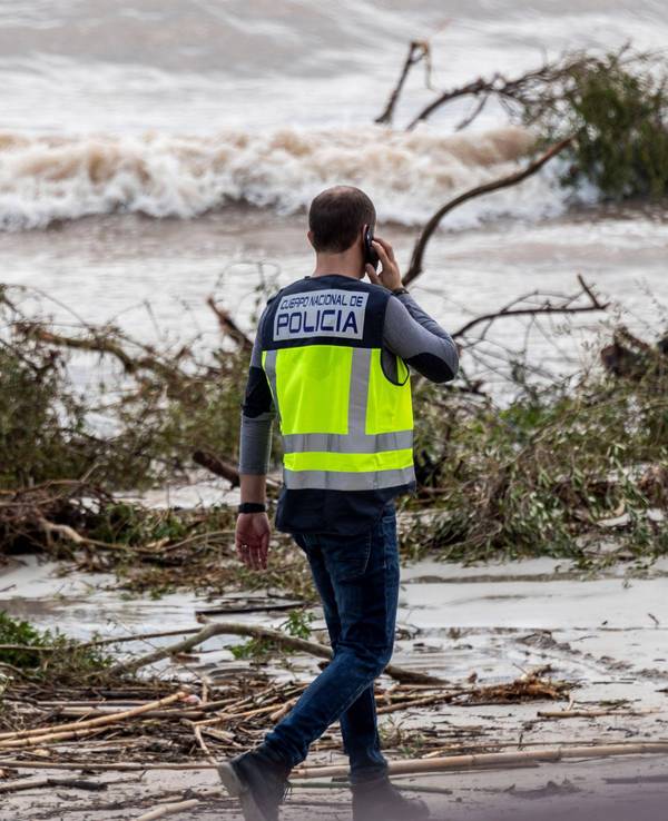 Ein Polizeibeamter ist nach der Flut von s'Illlot am Strand unterwegs.
