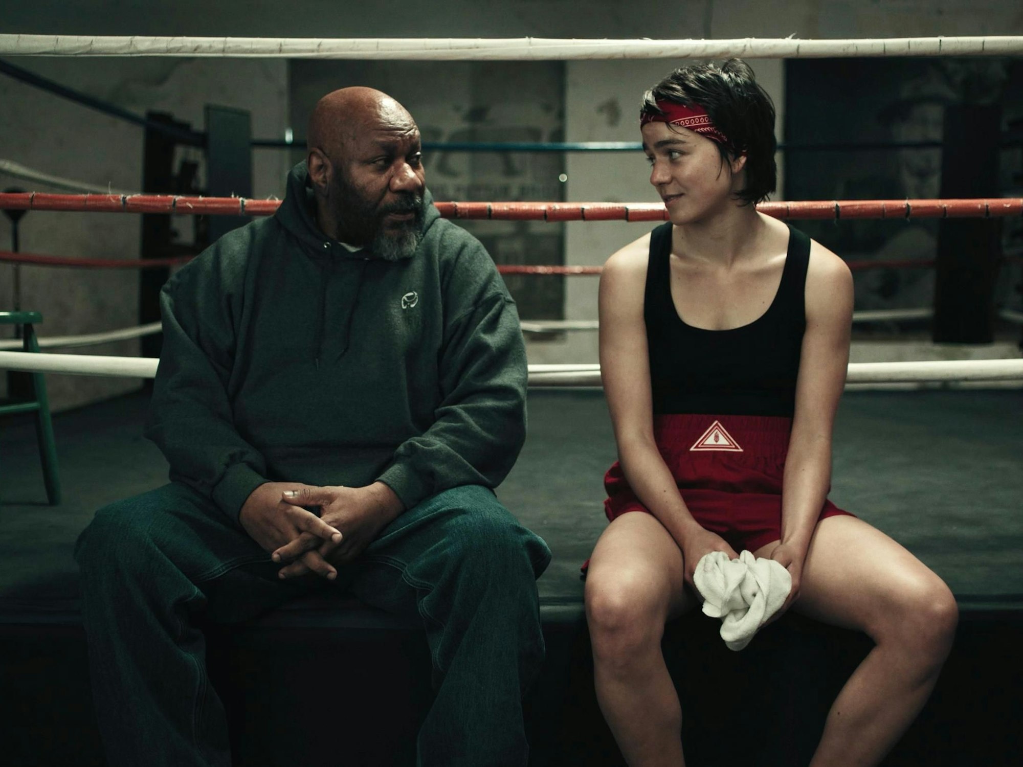 Ein Mann und eine Frau sitzen an einem Boxring.