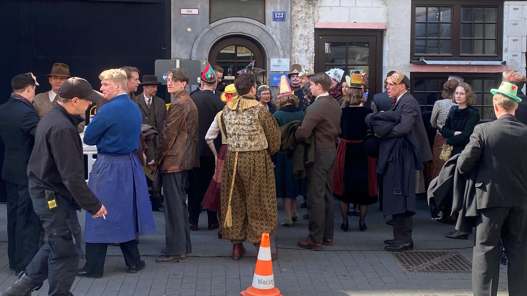 Komparsen und Komparsinnen stehen vor dem Brauhaus „Em kölsche Boor“.