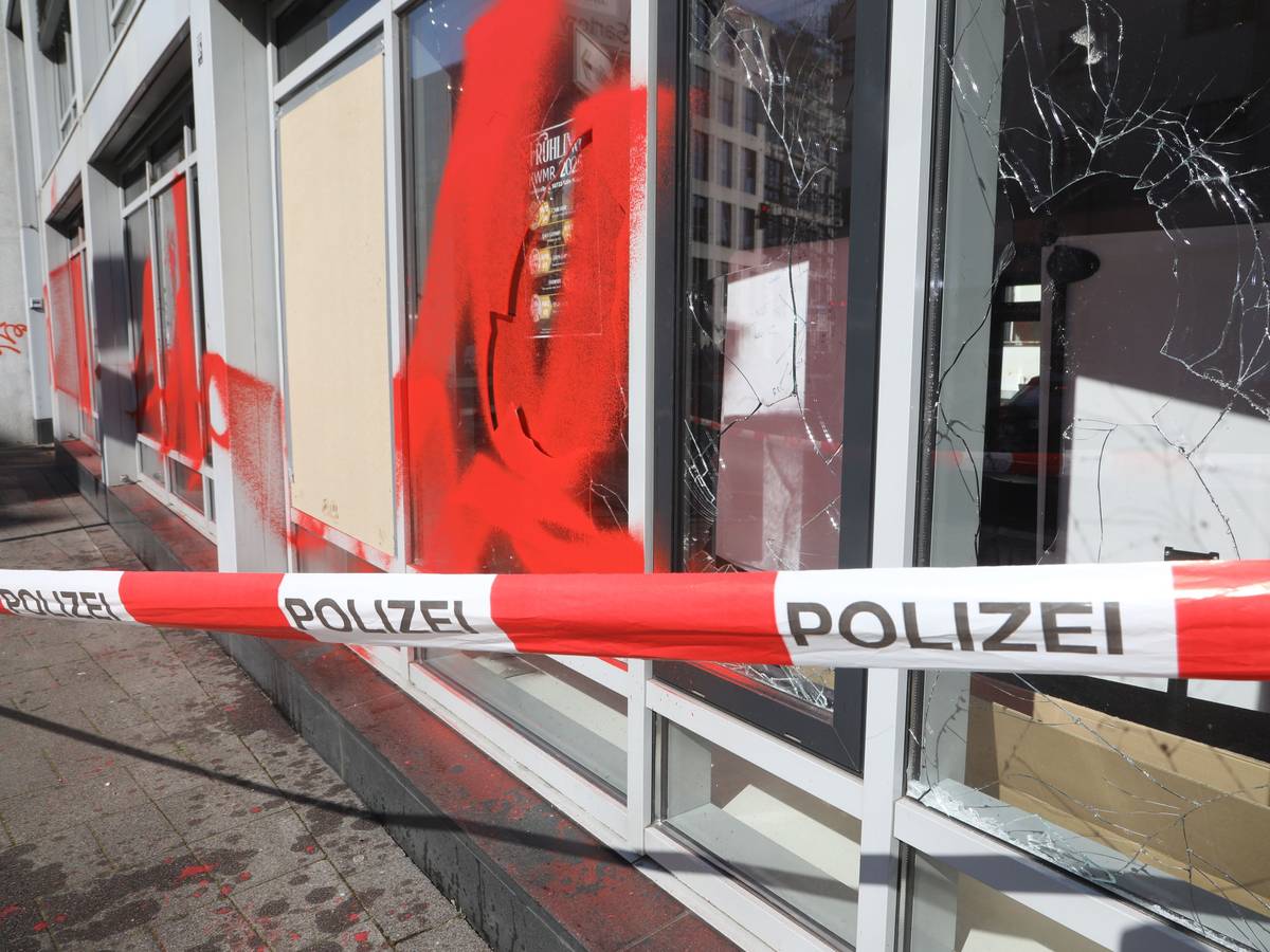 Drei Scheiben einer Fensterfront sind eingeworfen, ein Fenster sowie die Fassade mit roter Farbe besprüht worden.