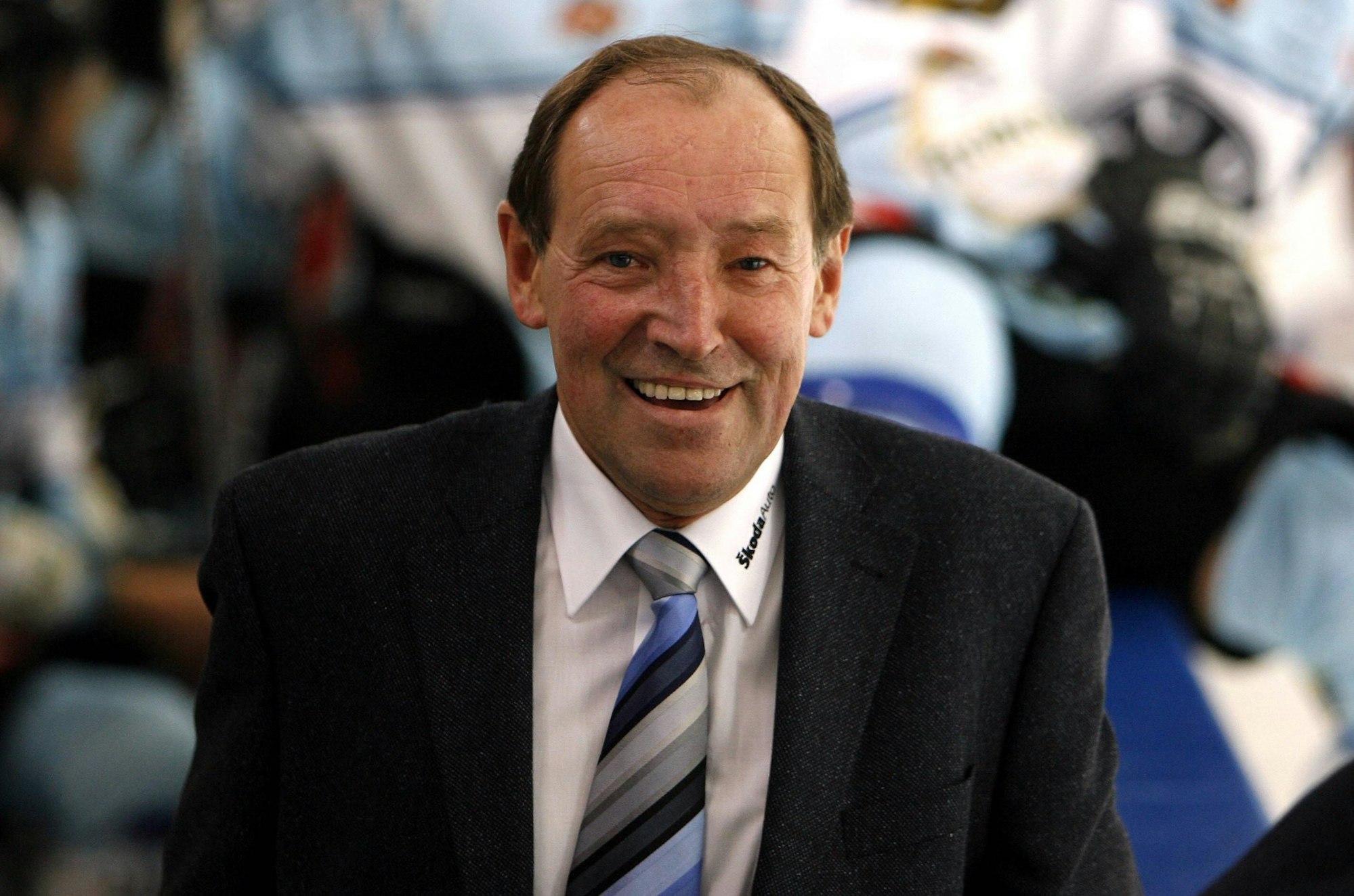 Jiri Kochta trägt einen Anzug und lächelt in die Kamera.