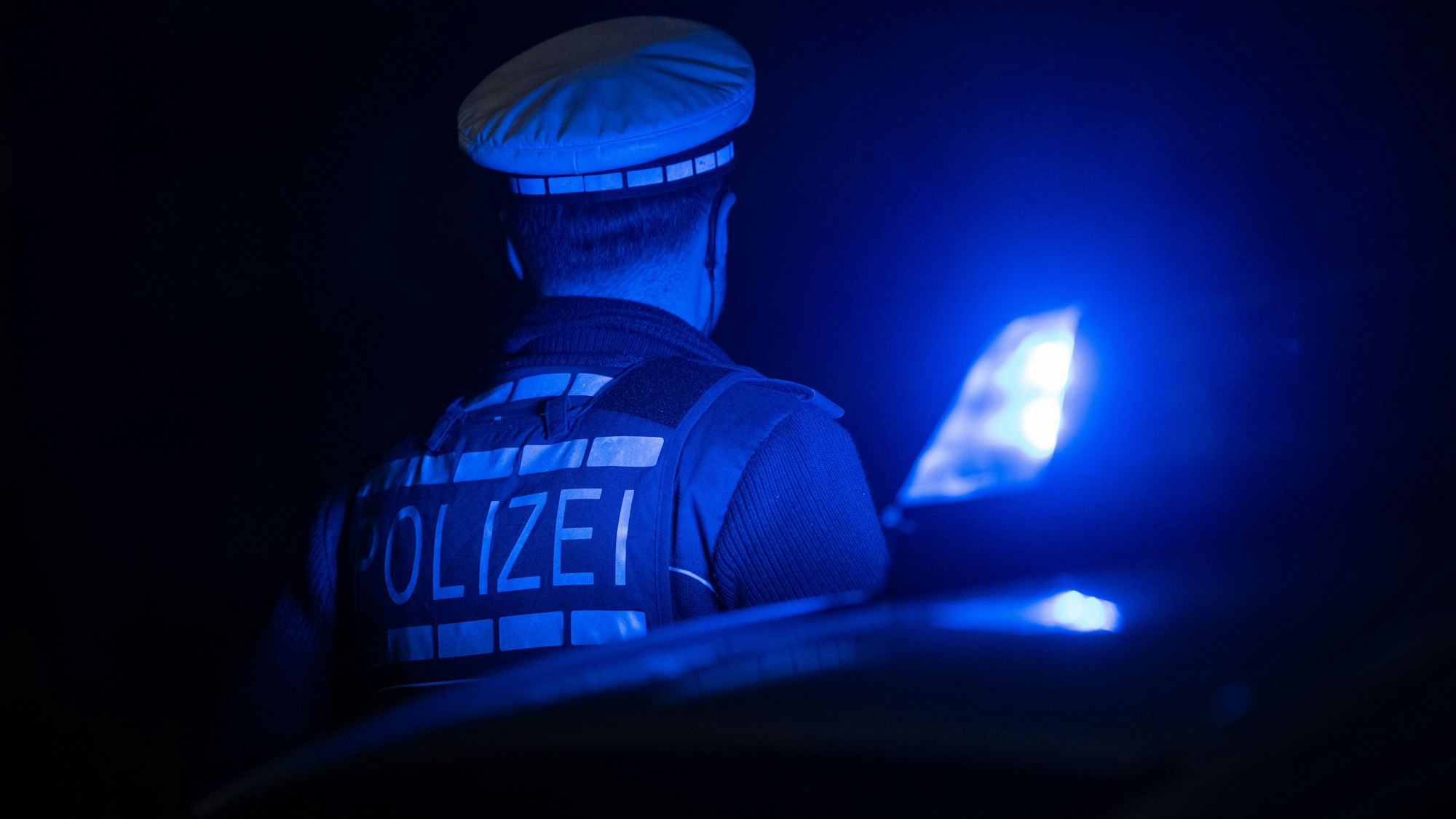 Ein Polizist bei einem Einsatz (Symbolfoto). In Düsseldorf gab es in der Nacht zu Samstag (5. April 2025) einen Raserunfall.